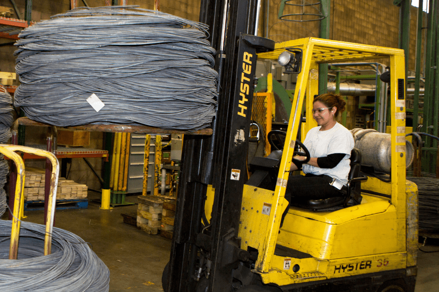 woman collecting metal on forklift